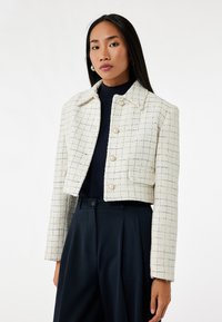 Witte en marineblauwe geruite cropped jasje van textuurstof, met een kraag, knopen aan de voorkant en zijzakken.