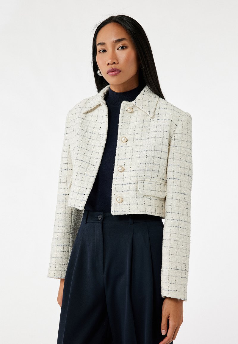 Witte en marineblauwe geruite cropped jasje van textuurstof, met een kraag, knopen aan de voorkant en zijzakken.