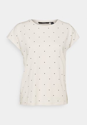 Cream short-sleeve t-shirt made of soft cotton, featuring a rounded neckline and a black polka dot pattern throughout.