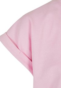 Rosa kortermet skjorte som viser et mykt, teksturert stoff. Har en litt senket skuldersøm og en ren, uformell kutt.