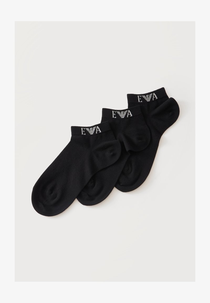 Trois paires de chaussettes noires basses avec texte blanc "EVA" et logo sur les bord-côtes, disposées sur un fond clair uni.