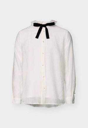 Hvid bluse med lange ærmer, flæset krave, knapper foran og sort fløjls sløjfe ved halsen.