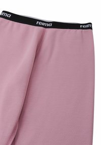 Różowe legginsy wykonane z teksturowanego, odprowadzającego wilgoć materiału. Posiadają czarny elastyczny pas z logo "reima" w białym kolorze.