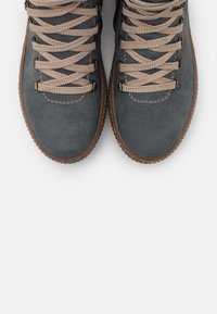 Botas de senderismo de ante gris con cordones beige, que cuentan con un upper texturizado y una suela de goma, mostrando un diseño duradero para el uso en exteriores.