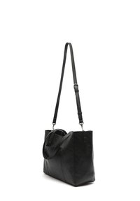 Black tote bag made of textured leather. Features two sturdy handles and a long adjustable strap, with a minimalist design and angular shape.