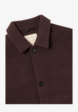 Abrigo de lana marrón con un cuello estructurado, que presenta un cierre de botón único y una tela suave y texturada. Etiqueta visible en el interior.