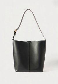 Bolso tote de cuero negro con cuerpo ancho y una sola correa para el hombro. Presenta una costura central y un diseño minimalista. Detalles en hardware dorado.