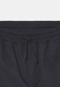 Granatowe kąpielówki z elastycznym pasem i regulowanym sznurkiem. Wykonane z gładkiego materiału, charakteryzujące się prostym wzorem.