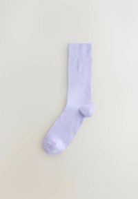 Calcetín de algodón lila con puño acanalado, textura suave y puntera reforzada. Diseño clásico sin logotipos ni patrones visibles.