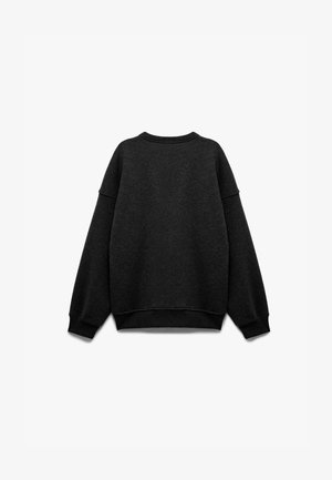 Sweatshirt noir à col rond avec coupe ample, poignets et ourlet côtelés, texture douce et coutures d'épaule tombantes. Pas de logos ou motifs visibles.