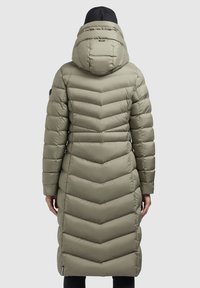 Long, olive green puffer coat with a chevron pattern, padded texture, and a detachable hood. Features a black accent near the collar.