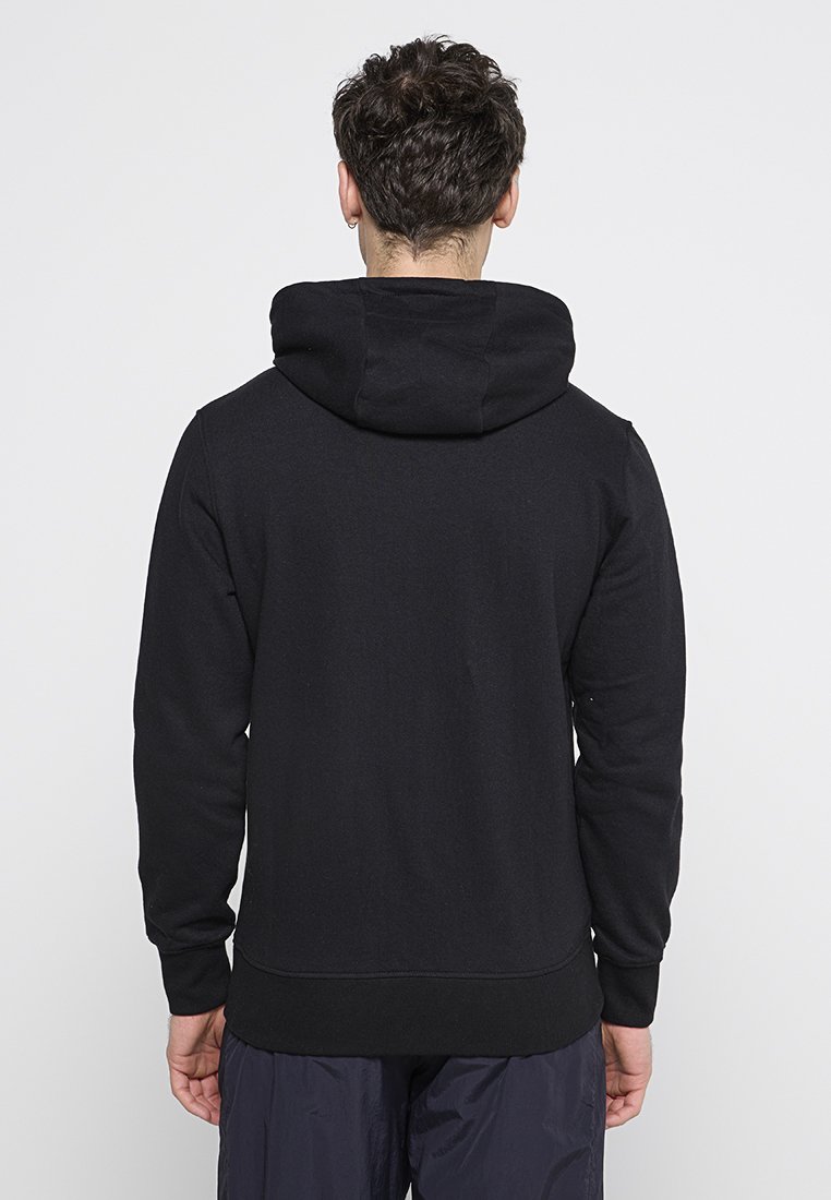 Sudadera negra hecha de una tela suave, con una gran capucha, puños de canalé y un diseño simple sin logotipos ni patrones visibles.