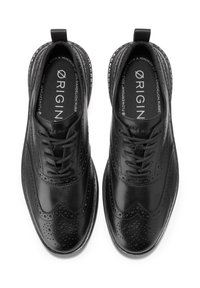 Černé kožené společenské boty s perforovanými detaily, kulatou špičkou, šněrovacím designem a texturovanou gumovou podrážkou vyrobenou z pampeliškového pryže.