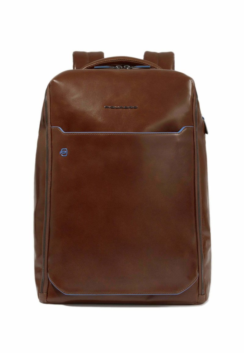 Mochila de cuero marrón con una textura suave, que presenta costuras de acento azules, un bolsillo delantero con cremallera y dos correas para los hombros.