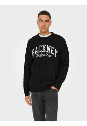 Schwarzer Strickpullover mit rundem Ausschnitt. Mit dem weißen Schriftzug "HACKNEY Dalston Lane" prominent über der Brust.