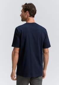 Marinblå t-shirt med kort ärm, tillverkad av mjuk bomull, med rund hals och avslappnad passform, med en jämn och slät yta.