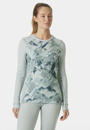 Lange mouwen sporttop in lichtgroen met een bergpatroon in donkerdere tinten. Rekbare stof, aansluitend ontwerp en platte naden voor comfort.