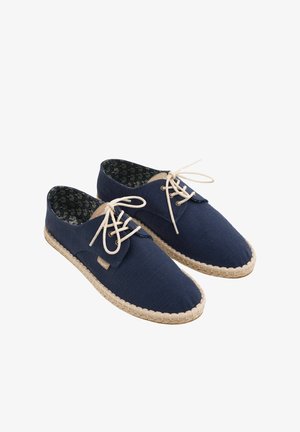 Granatowe espadryle materiałowe sznurowane z beżowymi plecionymi podeszwami i wzorzystą podszewką.