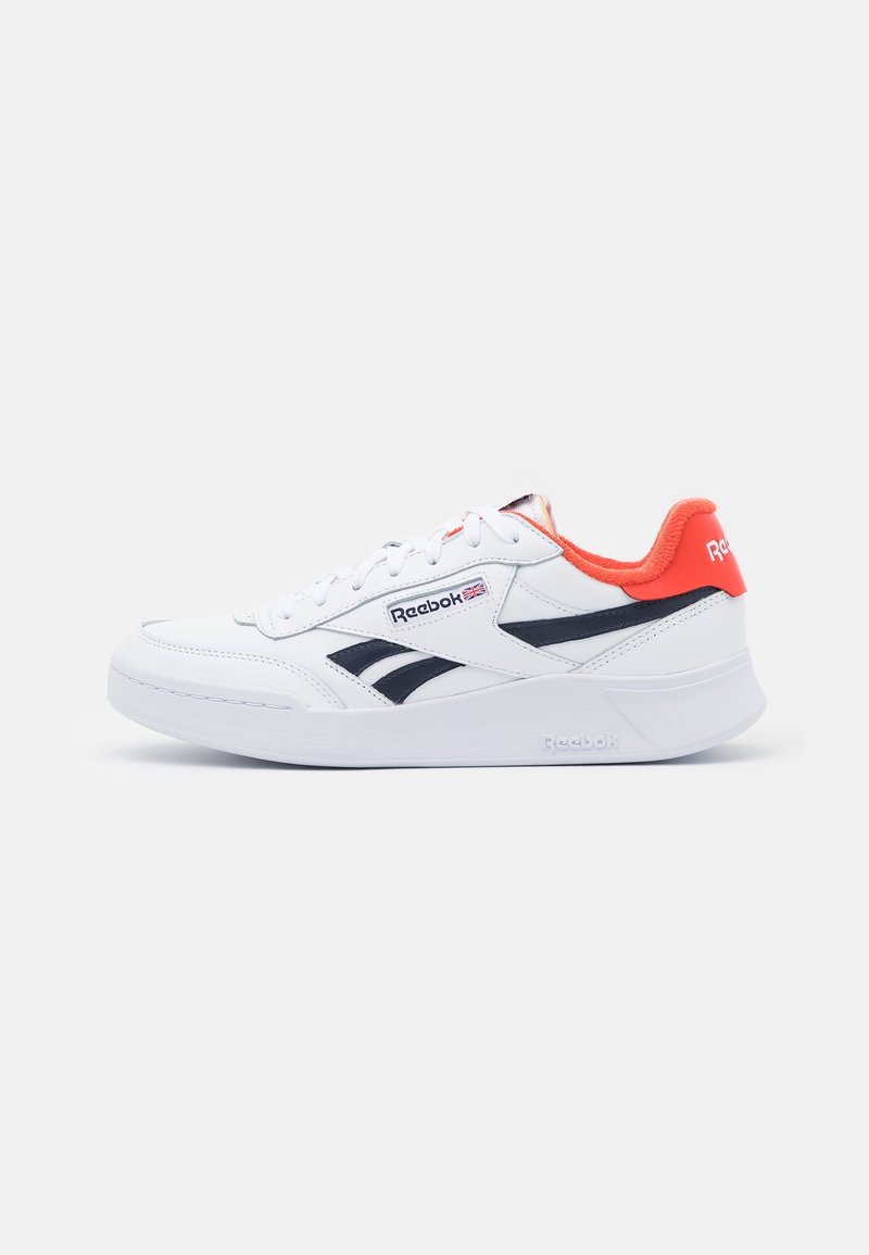 Baskets basses blanches Reebok avec logos noirs, doublure orange, lacets blancs et semelle blanche épaisse, vues de profil droit sur un fond blanc.