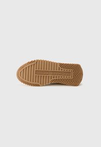 Brun gummisål til sneakers med struktureret fiskebensmønster, præget logo og varierende righøjder for forbedret greb.