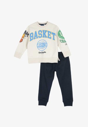 Sudadera crema con texto gráfico en azul y verde, diseños de baloncesto, combinada con pantalones jogger azul marino que tienen cintura elástica.