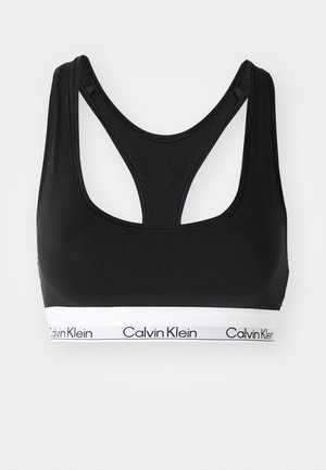 Zwarte sportbeha met een racerback ontwerp, gemaakt van zachte stof. Heeft een witte band met zwarte tekst "Calvin Klein" langs de onderkant.