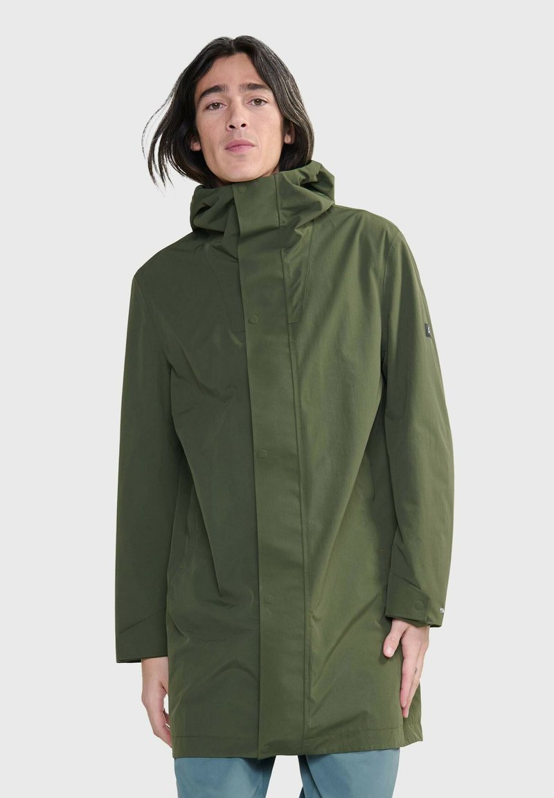 Giacca leggera verde con colletto alto e cappuccio, dotata di chiusura con bottoni, maniche lunghe e una finitura liscia e opaca.