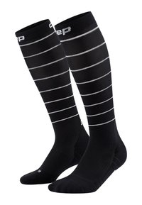 Black compression socks with white horizontal stripes. Made from elastic material, featuring a textured finish and reinforced toe and heel.