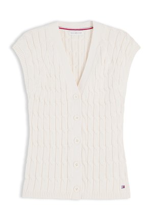 Αμάνικη λευκή ζακέτα πλεκτή με σχέδιο καλωδίων, V-λαιμόκοψη, πέντε κουμπιά μπροστά, ριμπ τελειώματα και ετικέτα με το λογότυπο Tommy Hilfiger κοντά στο τελείωμα.