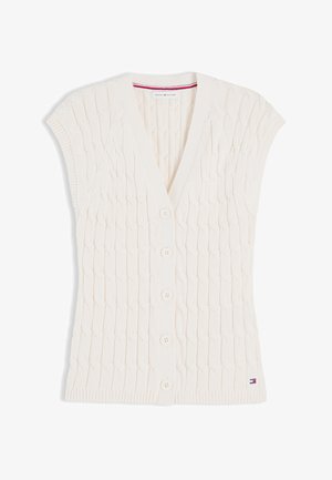 Αμάνικη λευκή ζακέτα πλεκτή με σχέδιο καλωδίων, V-λαιμόκοψη, πέντε κουμπιά μπροστά, ριμπ τελειώματα και ετικέτα με το λογότυπο Tommy Hilfiger κοντά στο τελείωμα.