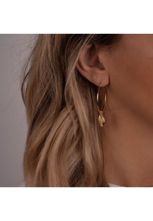 Arany karika fülbevalók kicsi kagyló charm-mal, elegáns dizájn, fényes felület és könnyű megjelenés.