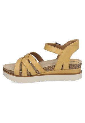 Yellow leather sandal with crisscross straps, cork footbed, and a white rubber wedge sole. Features an adjustable ankle strap.