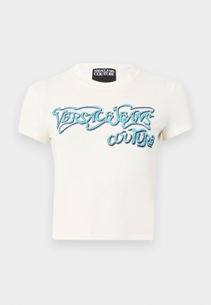 T-shirt court blanc ajusté à manches courtes avec le logo "Versace Jeans Couture" contouré de bleu sur la poitrine et une étiquette de marque noire au col.