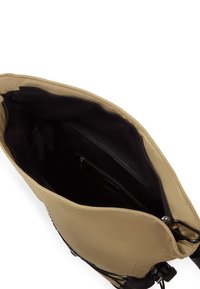 Beige toteväska med slät yta, bred öppning och svart foder. Har ett innerväskfack med dragkedja och två mindre fack.