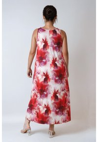 Robe maxi en tissu léger avec un motif floral dans des teintes rouges et violettes. Design sans manches avec une coupe décontractée et longueur cheville.