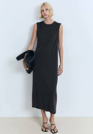 Sleeveless, knee-length dress in dark gray jersey fabric, featuring a rounded neckline and a relaxed fit. The model holds a textured black bag.