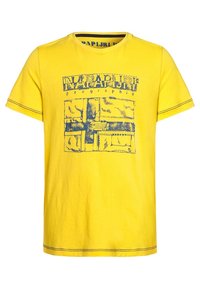 Keltainen puuvillapaita, jossa on sininen graafinen printti ja kontrastiväriset ompeleet kaula-aukossa ja helmassa. Rentouttava lyhythihainen malli.