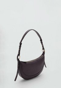 Bolso de cuero morado con forma curva, correa ajustable, acentos de hardware dorado y cierre de cremallera en la parte superior. Textura suave.
