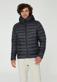 Svart puffjacka med huva, quiltad design, framdragkedja och två sidofickor. Lättviktig och mjuk textur.