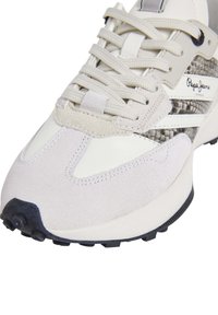Sneaker alta con tomaia in suede e pelle color crema, dettagli in pelle con stampa rettile testurizzata e suola in gomma scura con motivi di trazione.