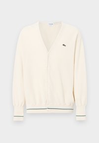 Cardigan color crema con scollo a V, chiusura con bottoni e polsini a costine che presentano strisce verdi. Piccolo logo sul petto.