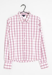Camisa de cuadros de manga larga blanca con un patrón de cuadros en rosa y gris, con botones al frente, cuello tipo punta y dobladillo redondeado con un acento fruncido.