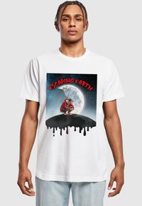 Hvit bomull t-skjorte med grafisk trykk av en person i hettegenser og hatt i rødt, med teksten "ESCAPING EARTH" og en månebakgrunn.