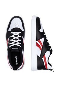 Mustvalged ja -valged tennisetossud punaste aktsentidega, millel on sile nahkpealne, ümar varvas, kuus paelaliselt auku ja kandmislõks kanna peal.