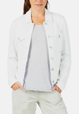 Weiße Denimjacke mit Knopfverschluss, zwei Brusttaschen und taillierter Passform. Über einem grauen Oberteil getragen, kombiniert mit hellen Hosen.