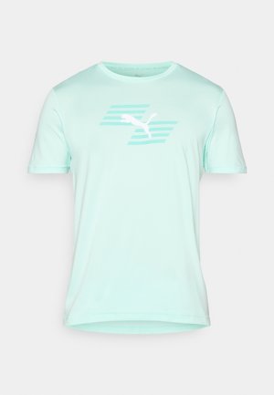 Myntgrønn t-skjorte med korte ermer laget av glatt stoff. Har et hvitt Puma-logo med horisontale striper over. Normal passform.