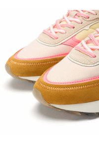 Sneakers featuring a beige and pink upper with a suede brown accent, textured overlays, and light-colored laces. Rounded toe with stitched details.