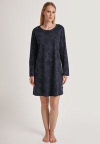 Camarina blu notte con maniche lunghe, scollatura rotonda e fantasie floreali. Texture morbida, design lungo fino al ginocchio con una vestibilità comoda.