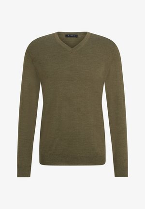 Oliwkowy sweter z dekoltem w serek zestawiony z jasnoszarymi zwężanymi dżoggerami. Strój ma prosty design i jest uzupełniony białymi sneakersami.