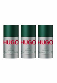 Tre deodoranter med gröna lock och silverfärgade behållare. Etiketten anger "HUGO MAN," med produktinformation i vit och grön text.